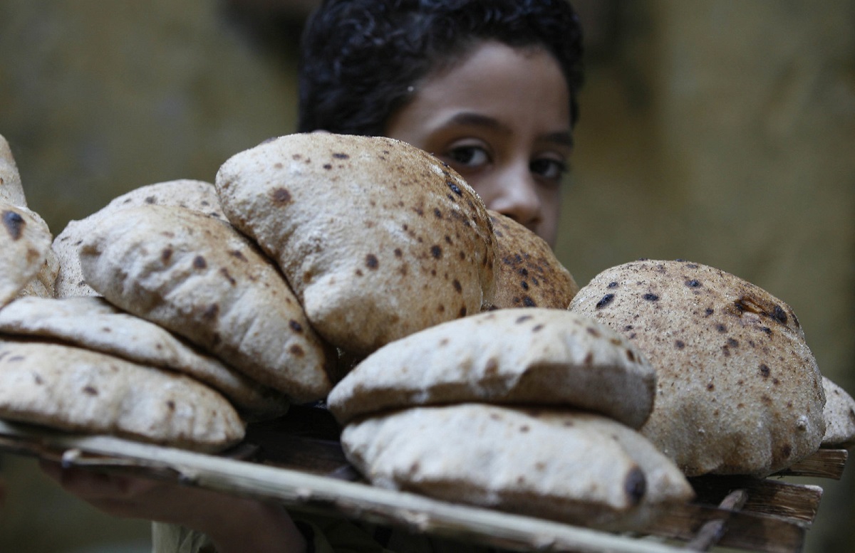 Bread loaves on tray with child's face behinid