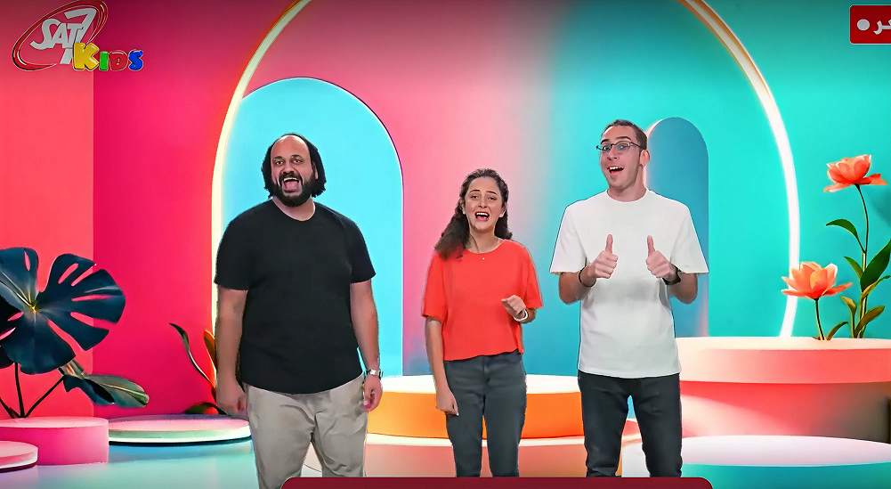 three presenters smile mid shot on SAT-7 KIDS set