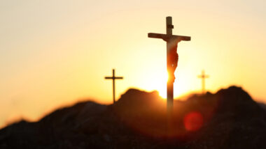 Three crosses on hill at sunrise