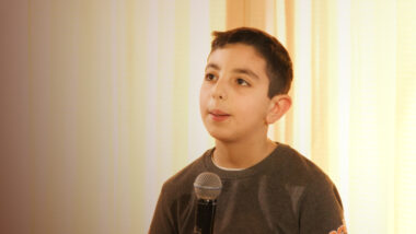 Boy speaking into microphone
