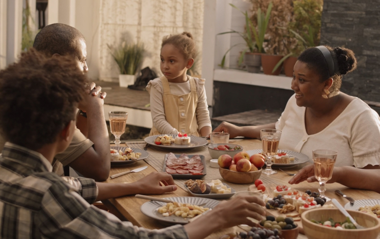 People sitting around a table eating and talking